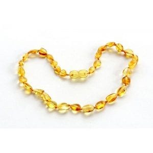 A yellow necklace is laying on the ground.