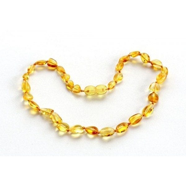 A yellow necklace is laying on the ground.