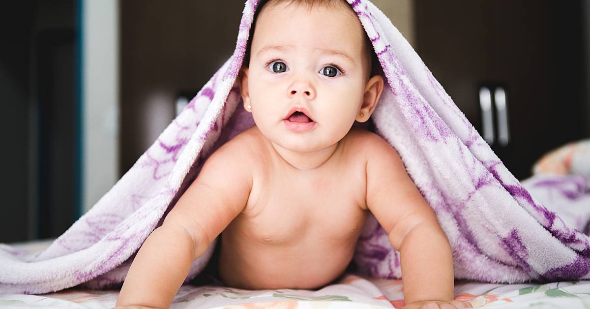 photo of a baby under a purple towel