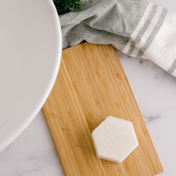 A wooden cutting board with cheese on it.